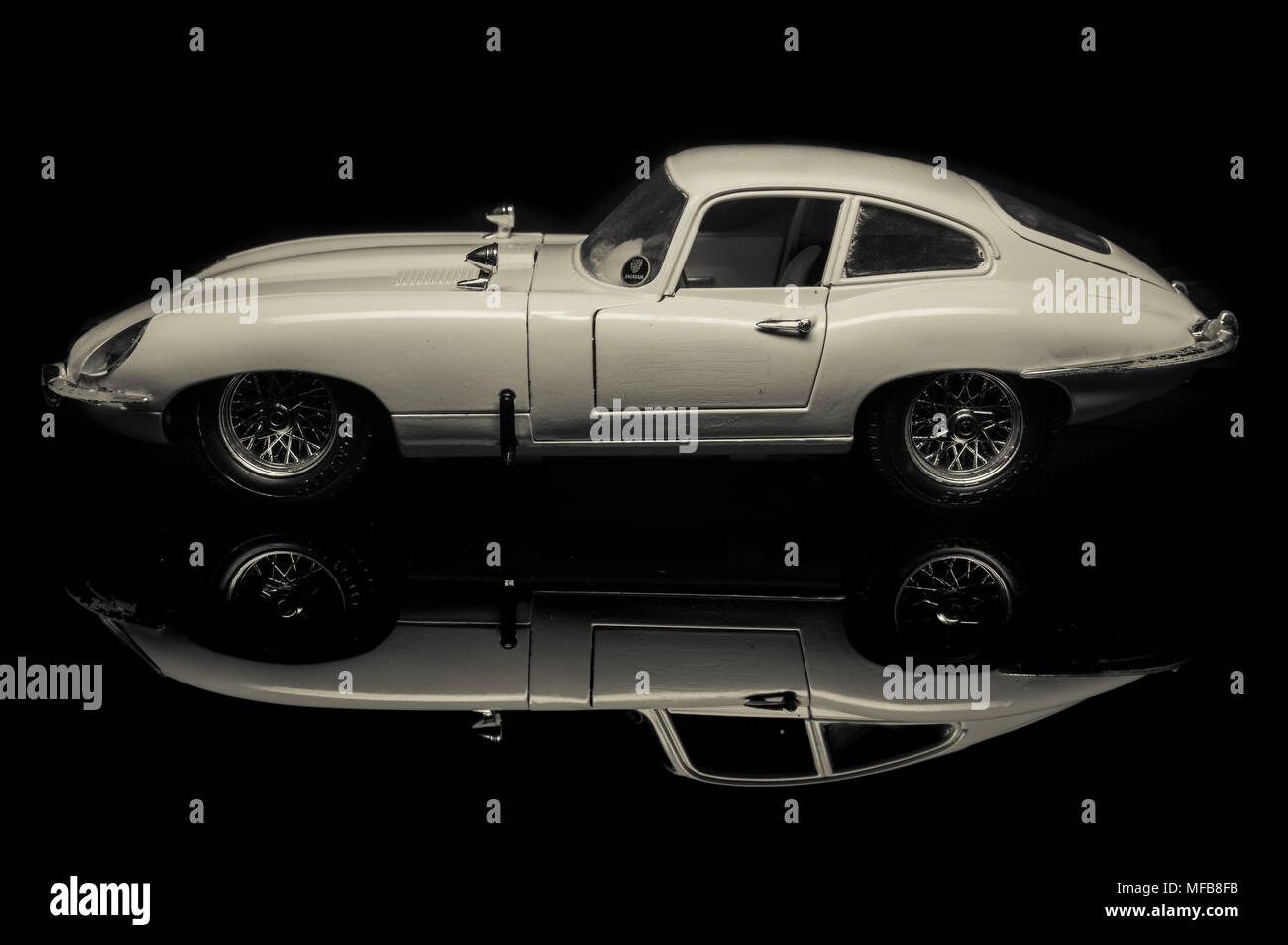 Black and white studio image of a toy Jaguar E type 4.2 coupe classic car. Stock Photo