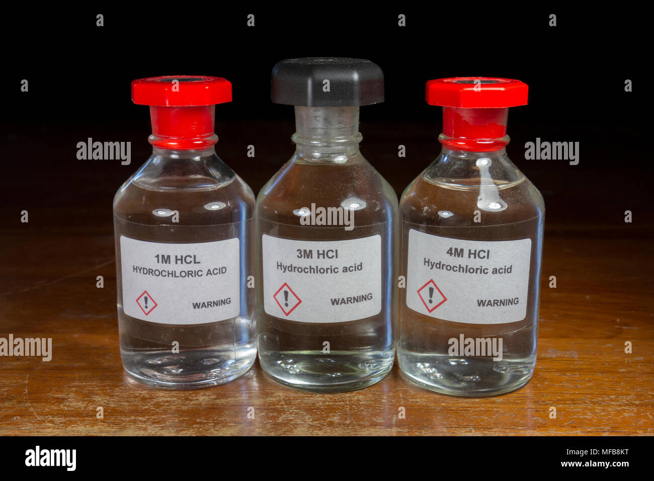 Three bottles of hydrochloric acid (1M, 3M and 4M) school acids as used in a UK secondary/high school. Stock Photo