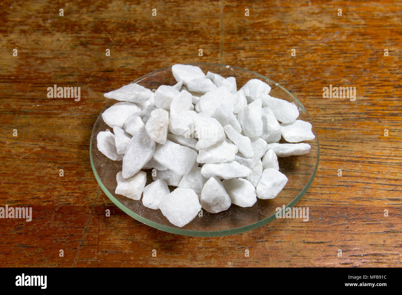 A watch glass of large chips of calcium carbonate (marble) as used in a UK Secondary/High school. Stock Photo