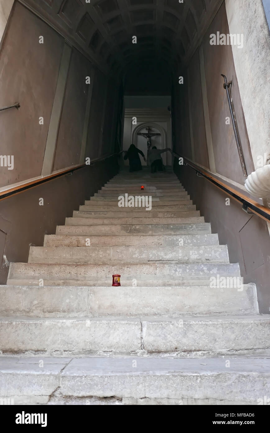 VATICAN CITY, VATICAN STATE -  APRIL 10, 2018: people Climb the  Borgo Santo Spirito Holy Stairs on one's knees perform the  Scala Sancta devotion Stock Photo