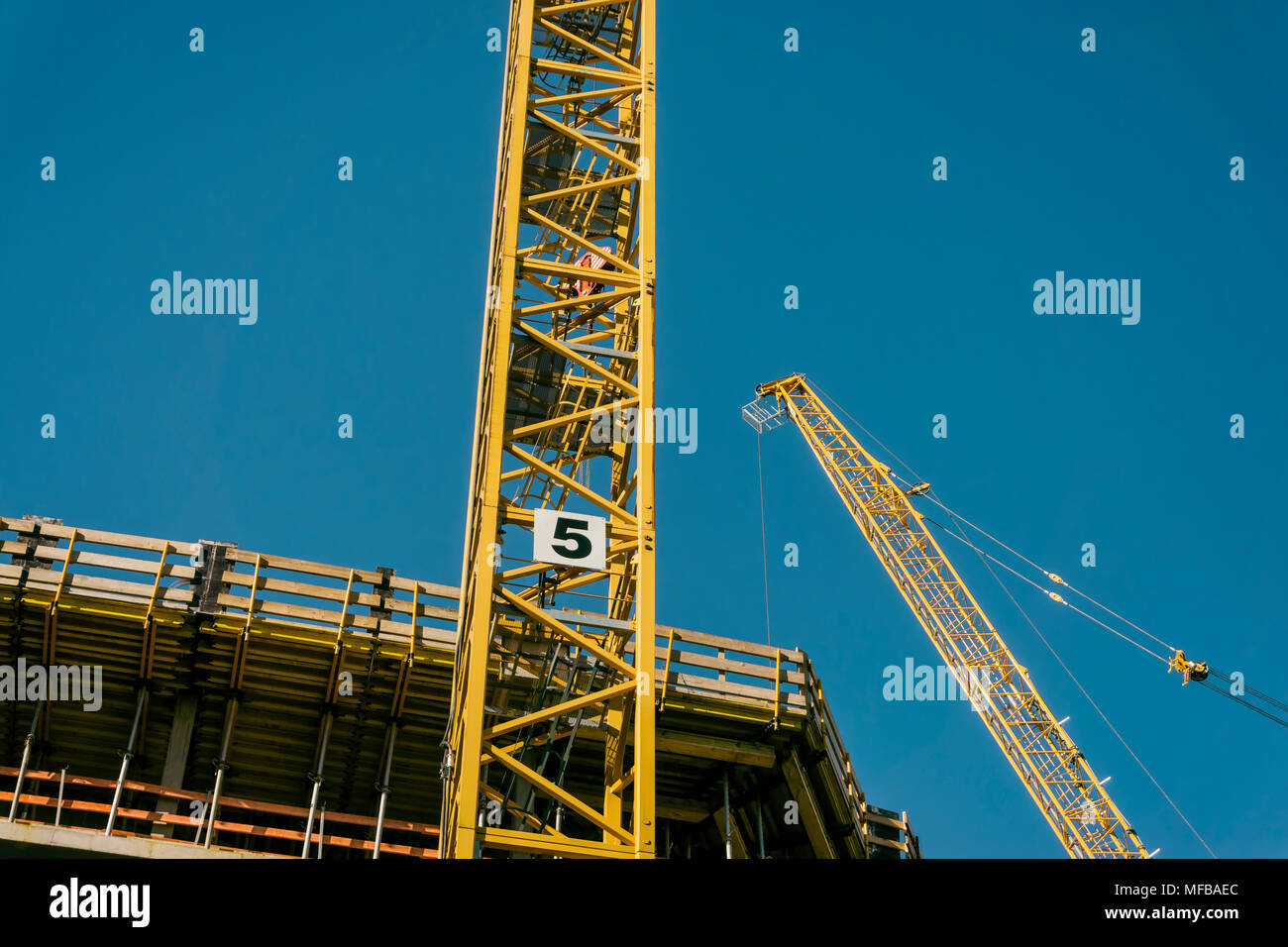 Two cranes at construction site Stock Photo