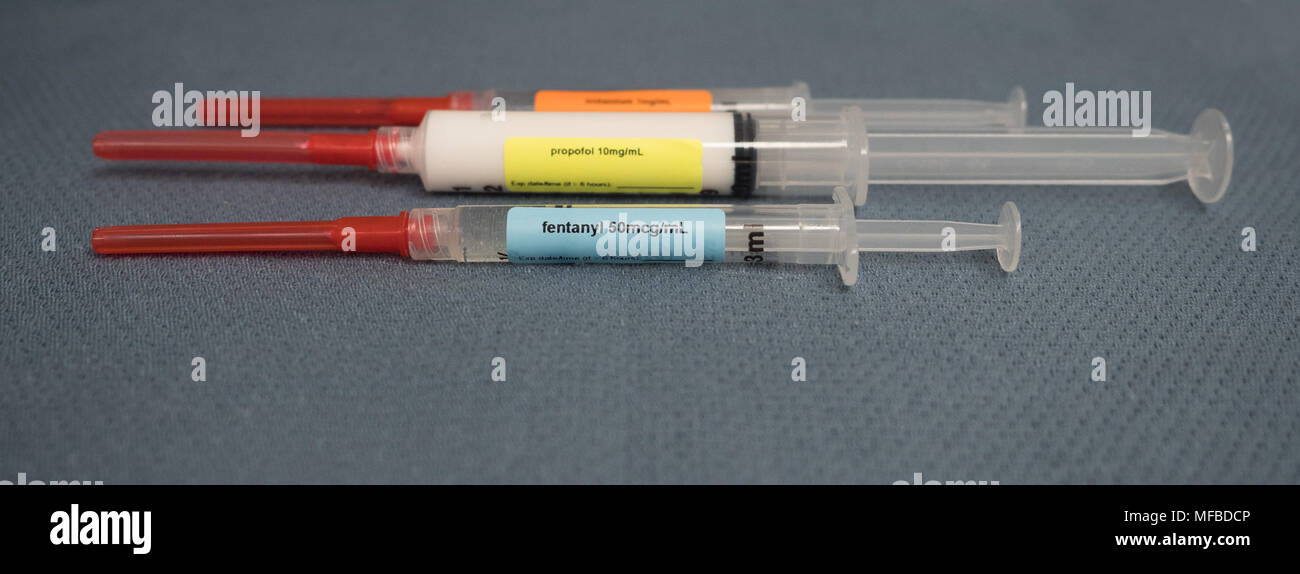 Three labeled syringes with red capped safety needles containing drugs