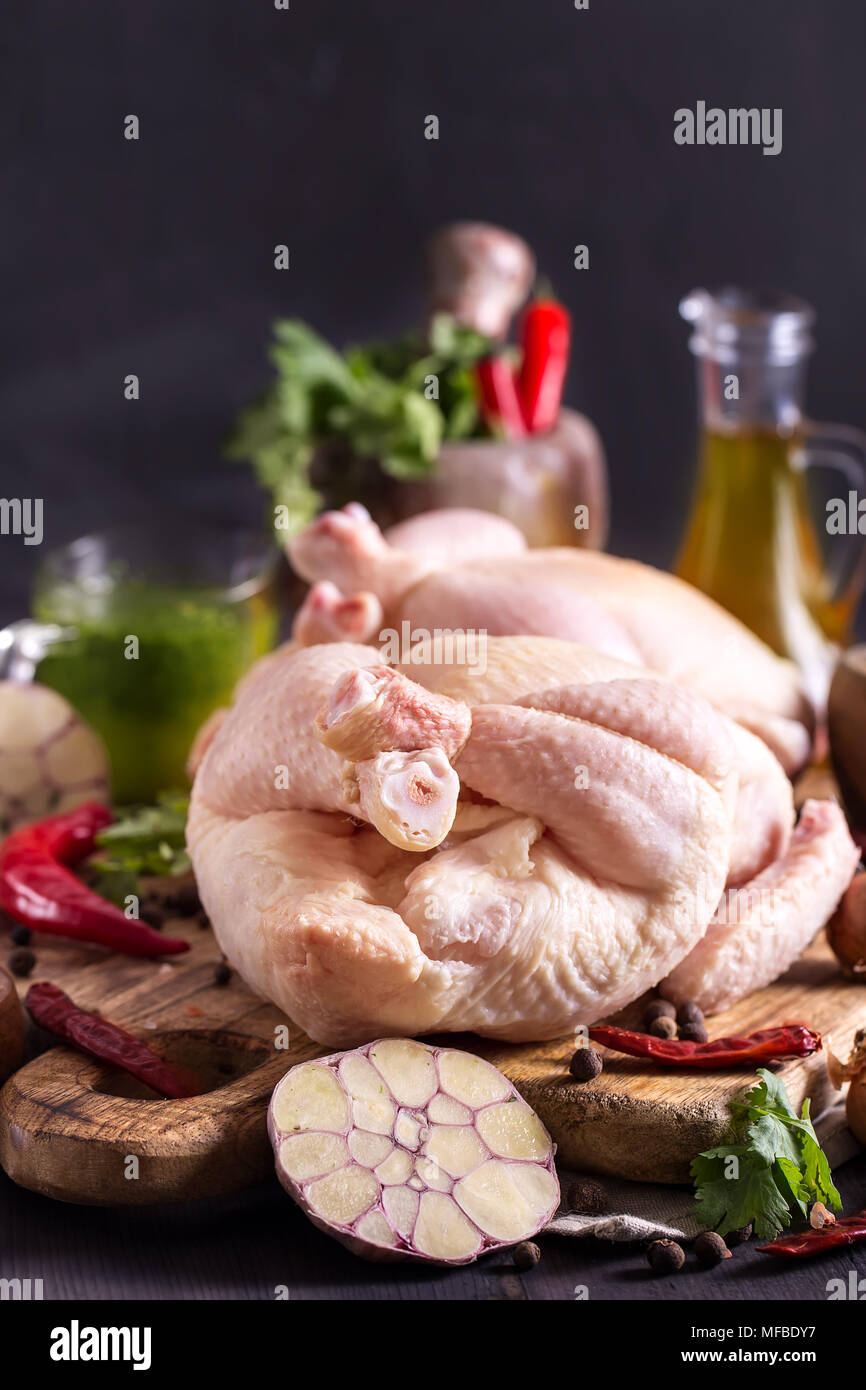 Two raw chickens on rustic wooden board with herbs and spices Stock