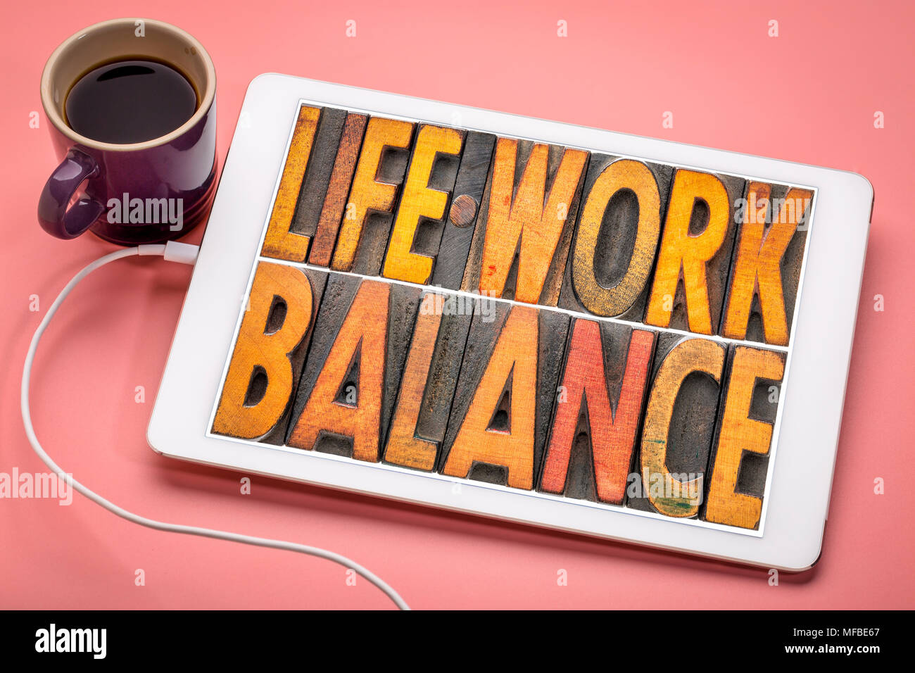 life work balance - word abstract in vintage letterpress wood type on a digital tbalet with a cup of coffee Stock Photo