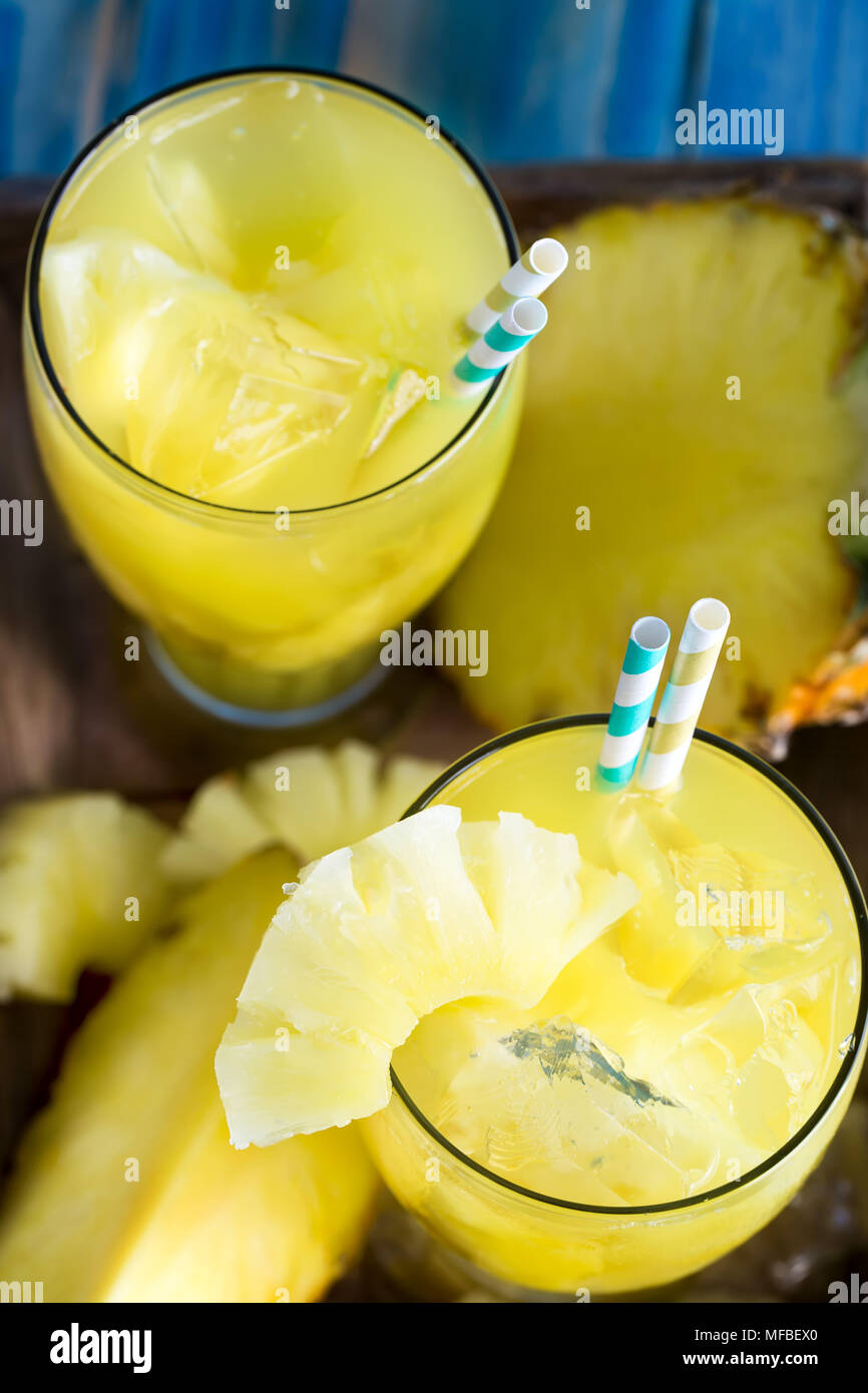 Pineapple juice and fresh ripe pineapple on wooden background Stock Photo