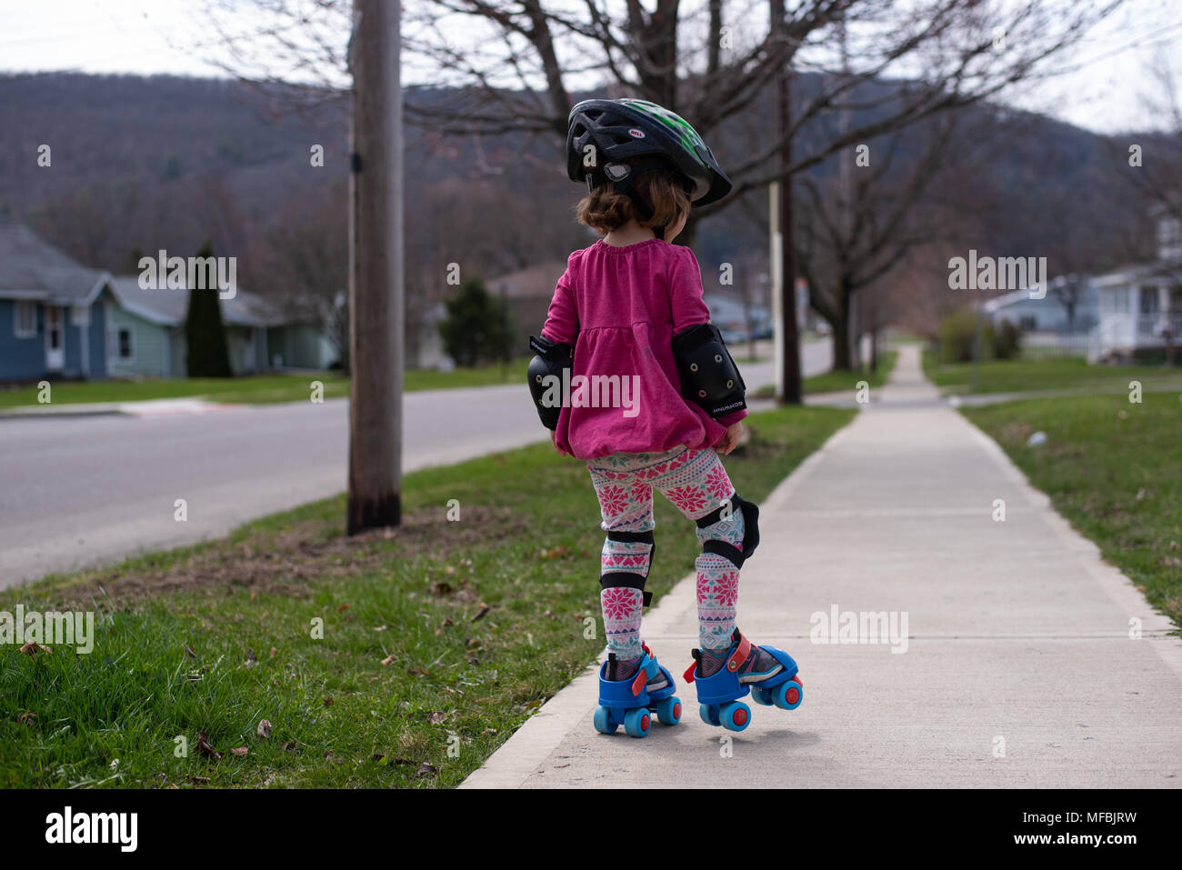 A toddler girl puts on a pair of roller skates Stock Photo Alamy