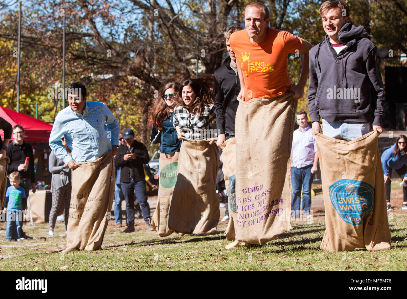 Young adults compete in a sack race at the King of Pops Festival in Atlanta, GA on November 14, 2015. Stock Photo