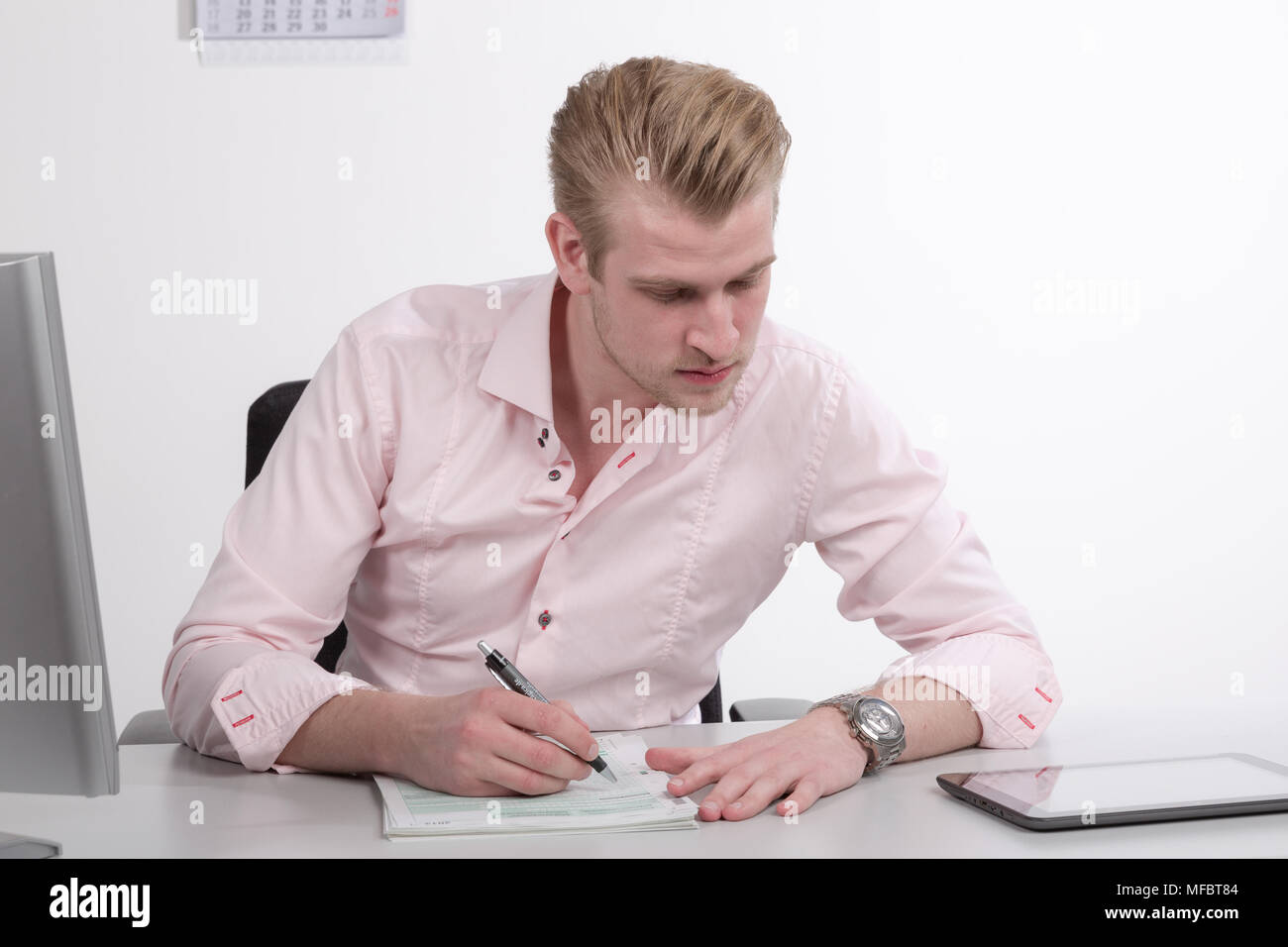 Young man working at desk on paper work Stock Photo