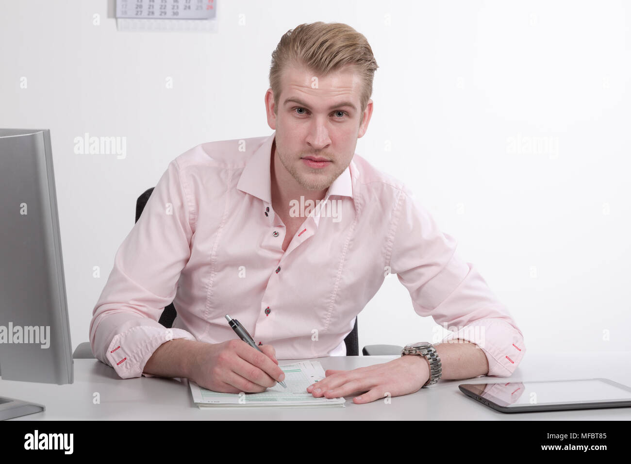 Young man working at desk on paper work Stock Photo