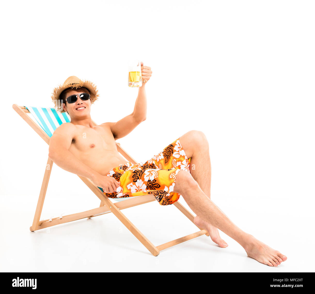 Relaxed man sitting in lounger chair and drinking beer Stock Photo