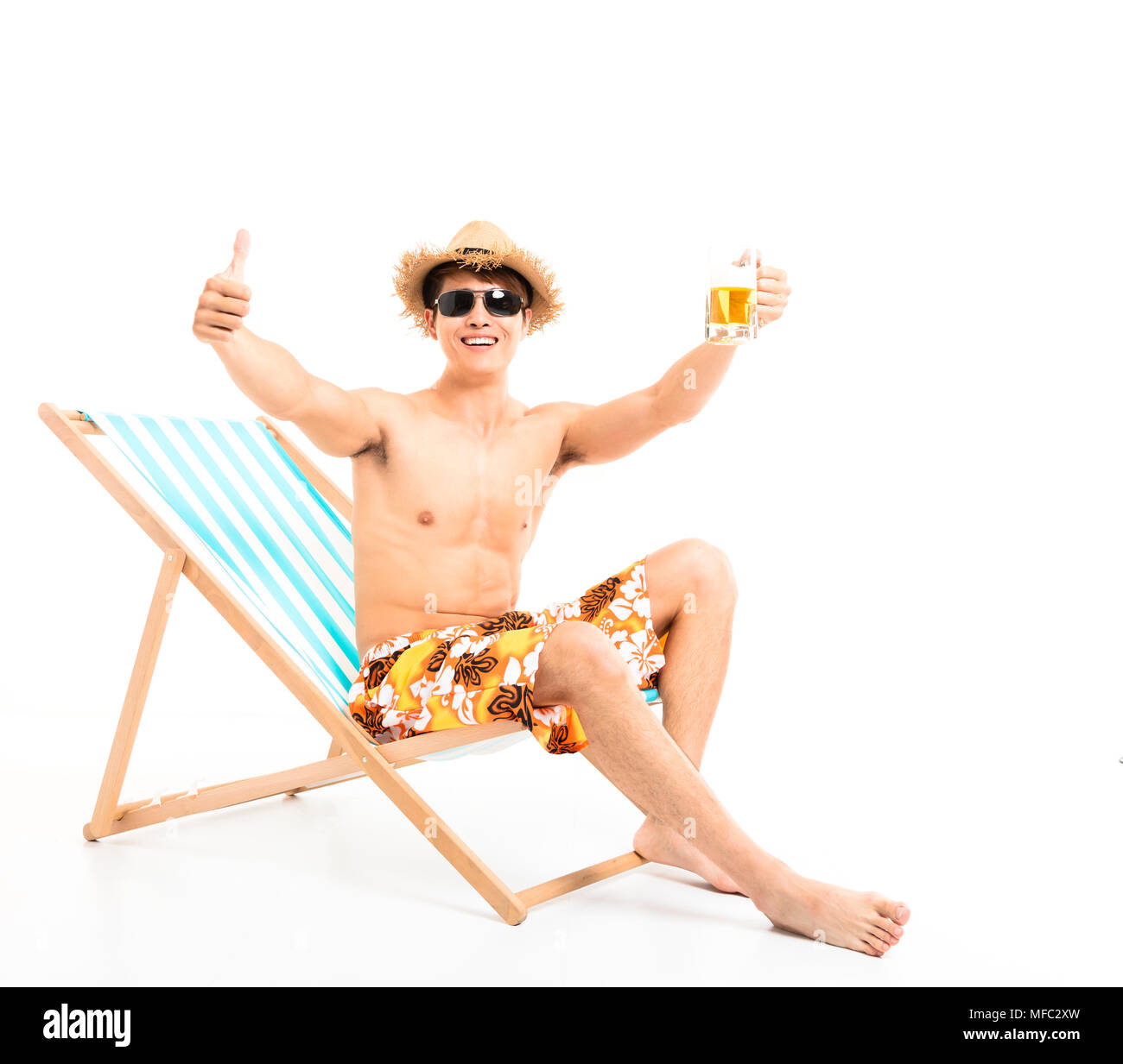 Relaxed man sitting in lounger chair and drinking beer Stock Photo