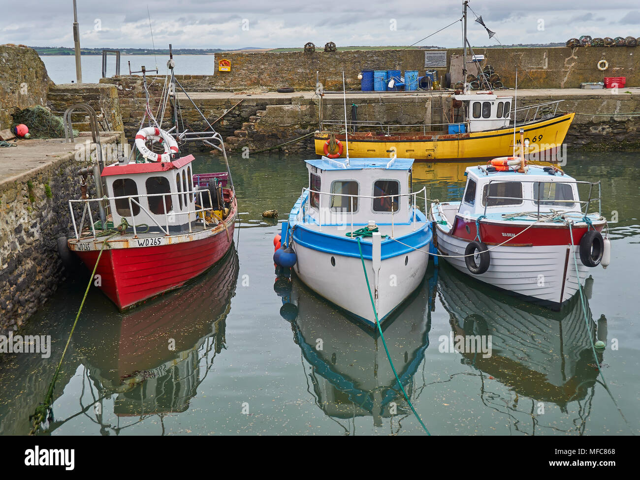 Four Colourful Local Irish Fishing Boats moored up at low tide in Fethard  Harbour in County Wexford, Southern Ireland Stock Photo - Alamy