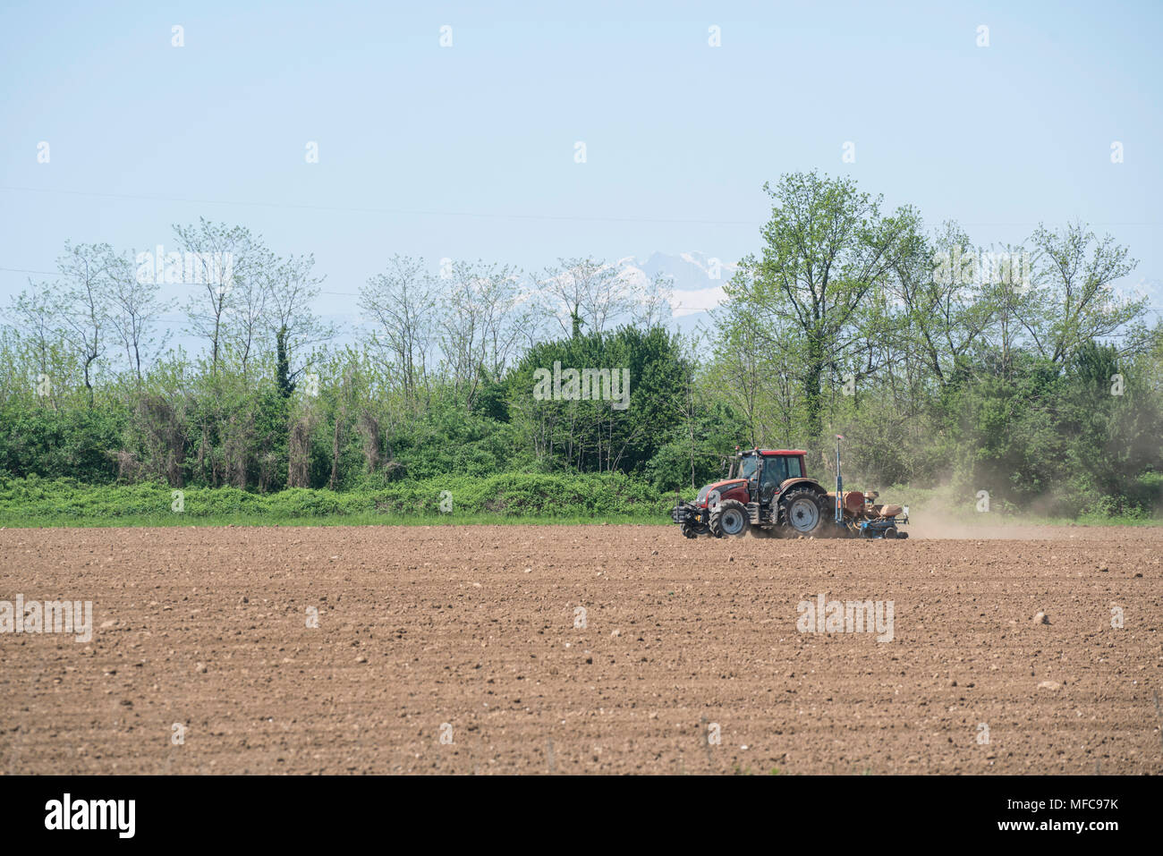 an agricultural tractor while plowing the fields at springtime Stock Photo