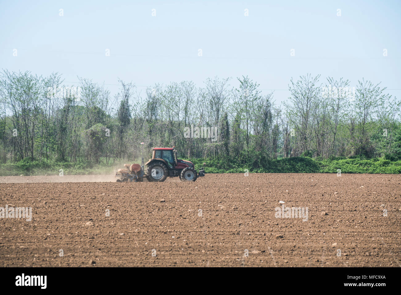 an agricultural tractor while plowing the fields at springtime Stock Photo