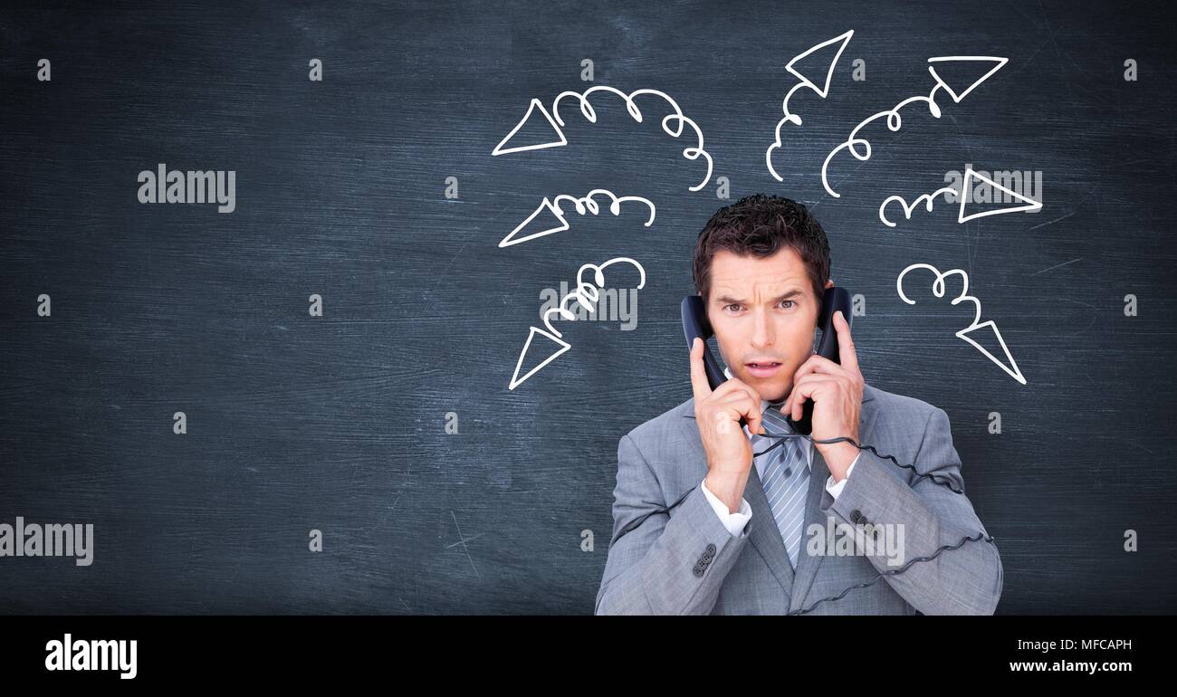 Stressed businessman on phones with arrow doodles on blackboard Stock Photo