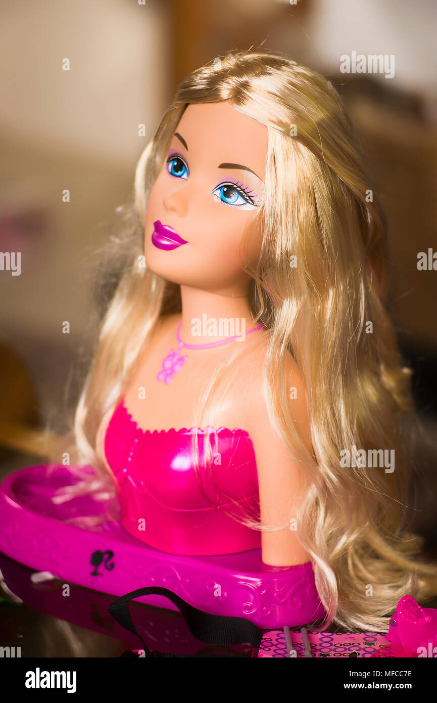 An attractive doll with long blonde hair used by a child to practise hairdressing in UK Stock Photo