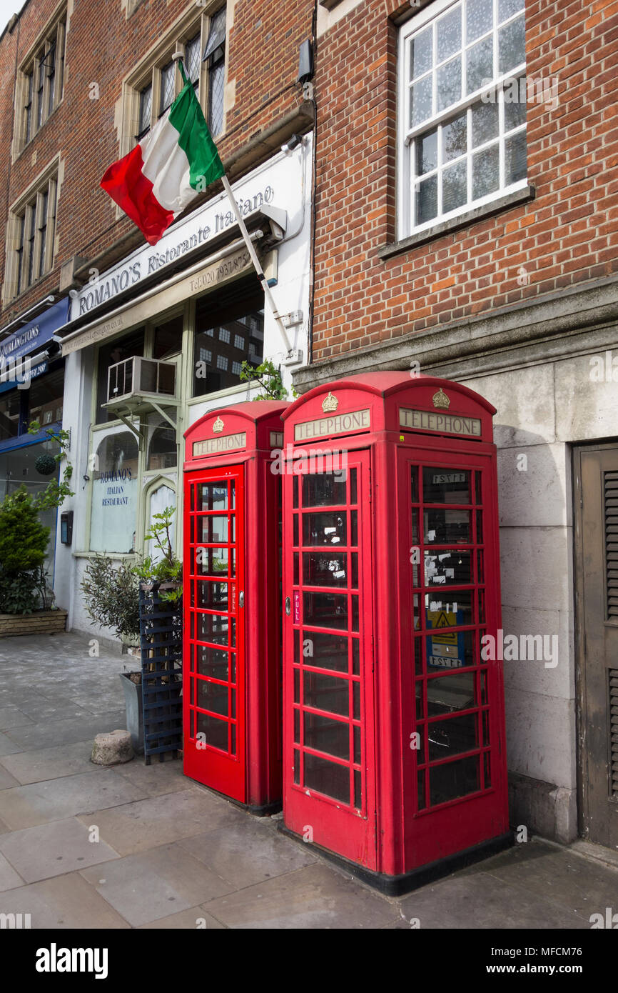 Two of Sir Giles Gilbert Scott's iconic K6 red telephone boxes (still functioning) on Church Street, Kensington, London, W8, UK Stock Photo