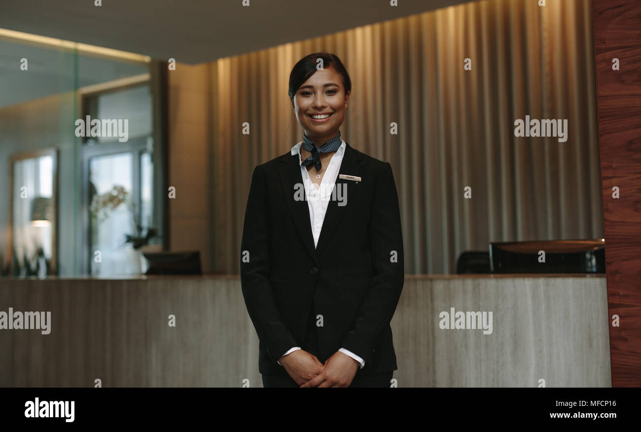 Young Smiling Female Receptionist At The Hotel Front Desk Ready To