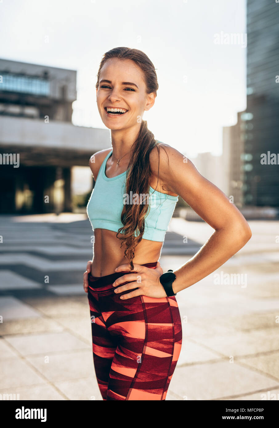 https://c8.alamy.com/comp/MFCP8P/portrait-of-sportswoman-smiling-outdoors-in-morning-female-in-running-outfit-standing-outdoors-in-city-MFCP8P.jpg