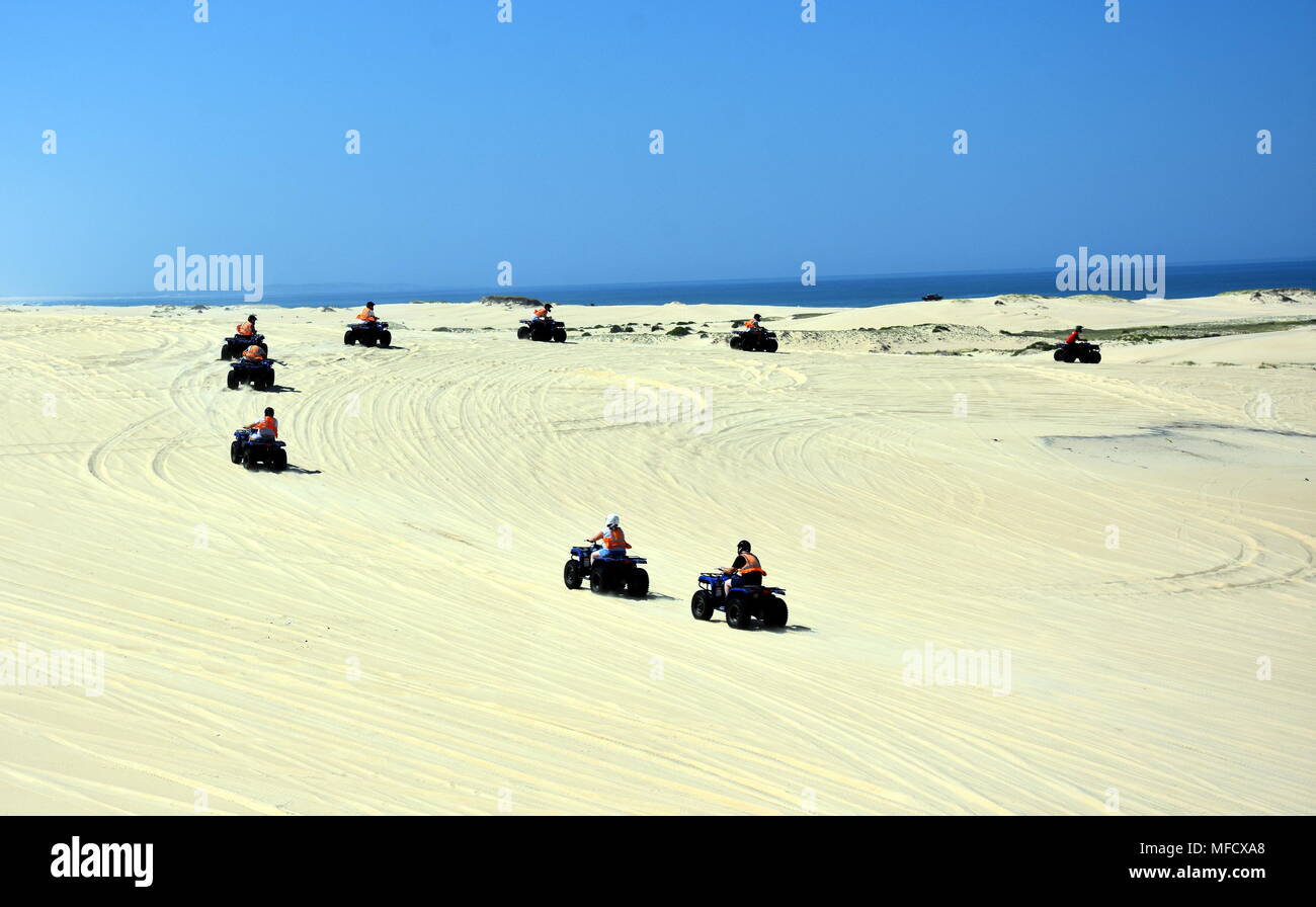Happy quad bikers driving in sand dunes at Anna bay (Newcastle, NSW