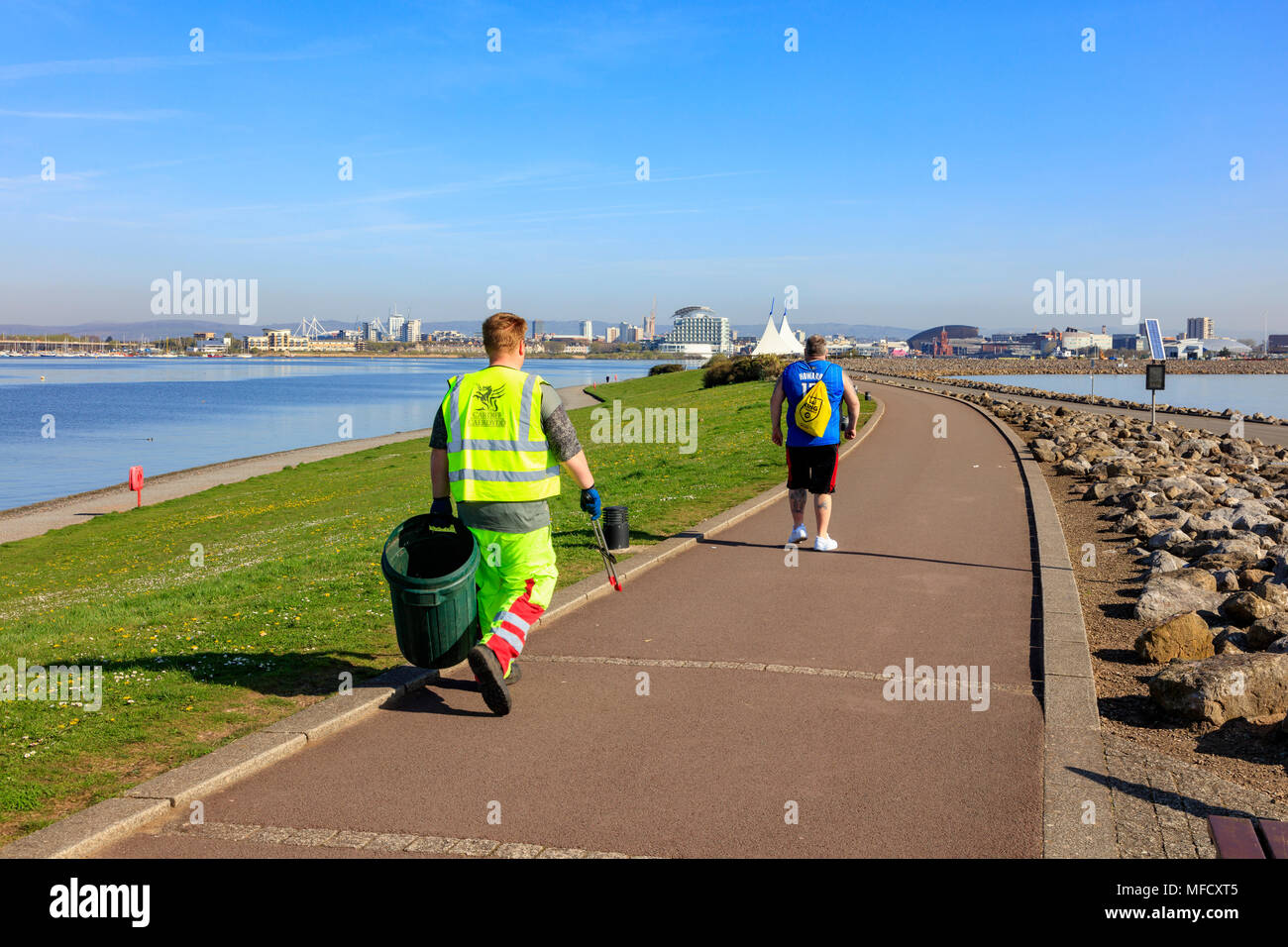 A council worker picks up rubbish on the Wales Coast Path as it crosses the Cardiff Bay Barage
