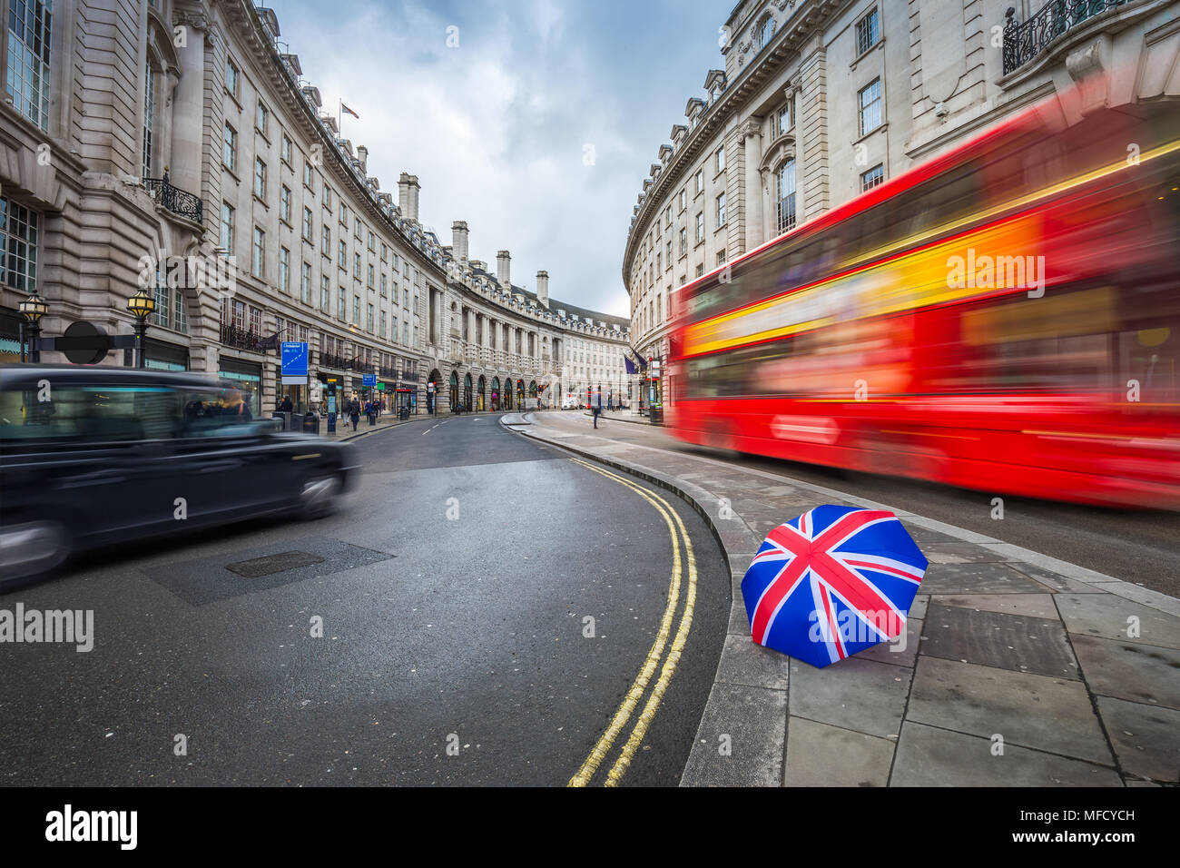 London, England - Iconic red double-decker bus and black taxi on the move on Regent Street with british umbrella Stock Photo