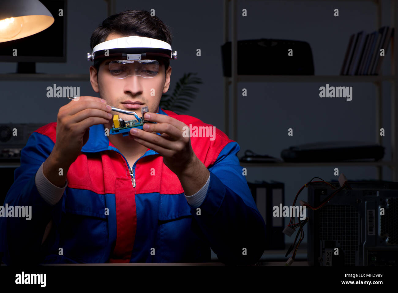 Computer specialist repairing PC late at night Stock Photo - Alamy