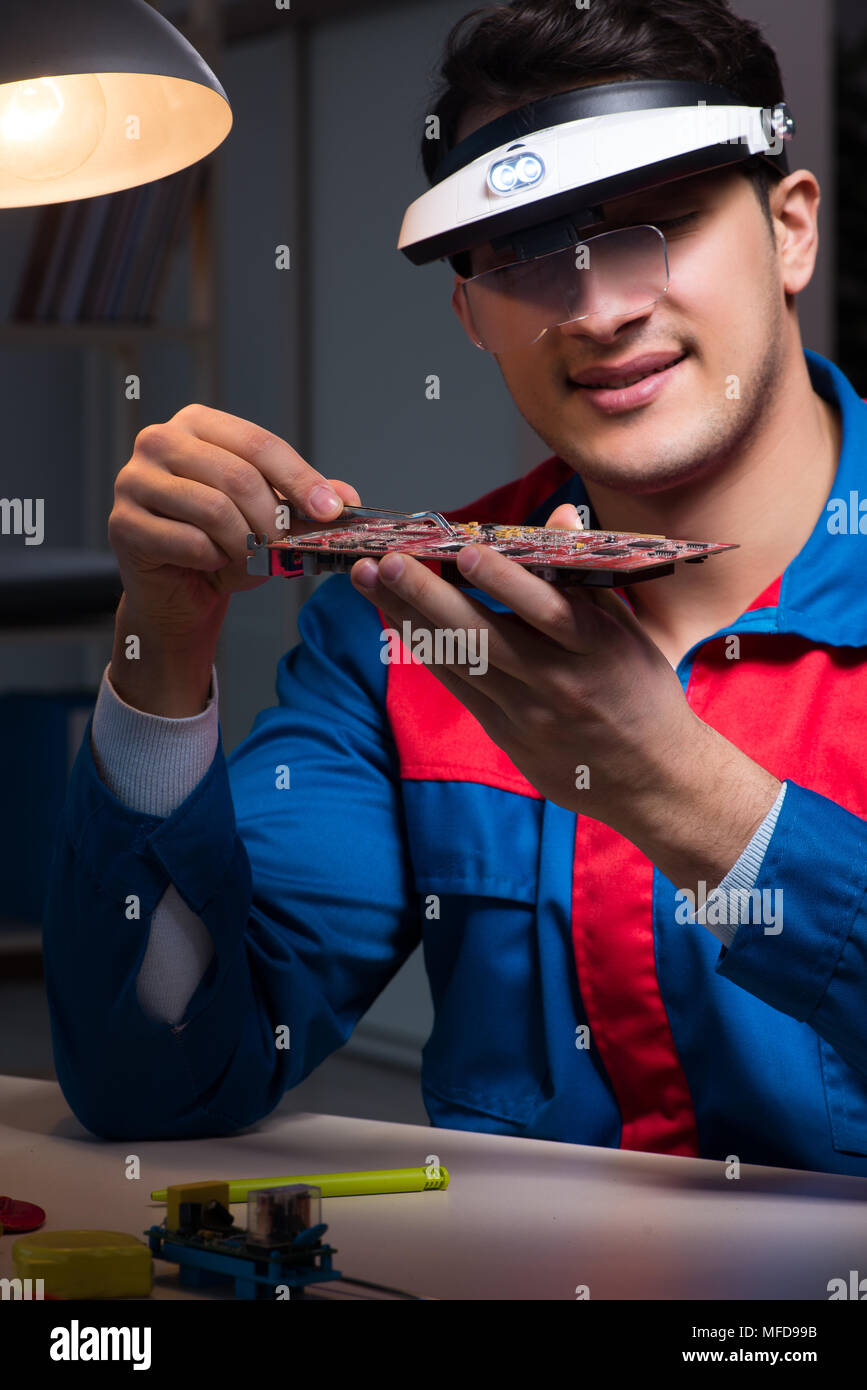 Computer specialist repairing PC late at night Stock Photo - Alamy