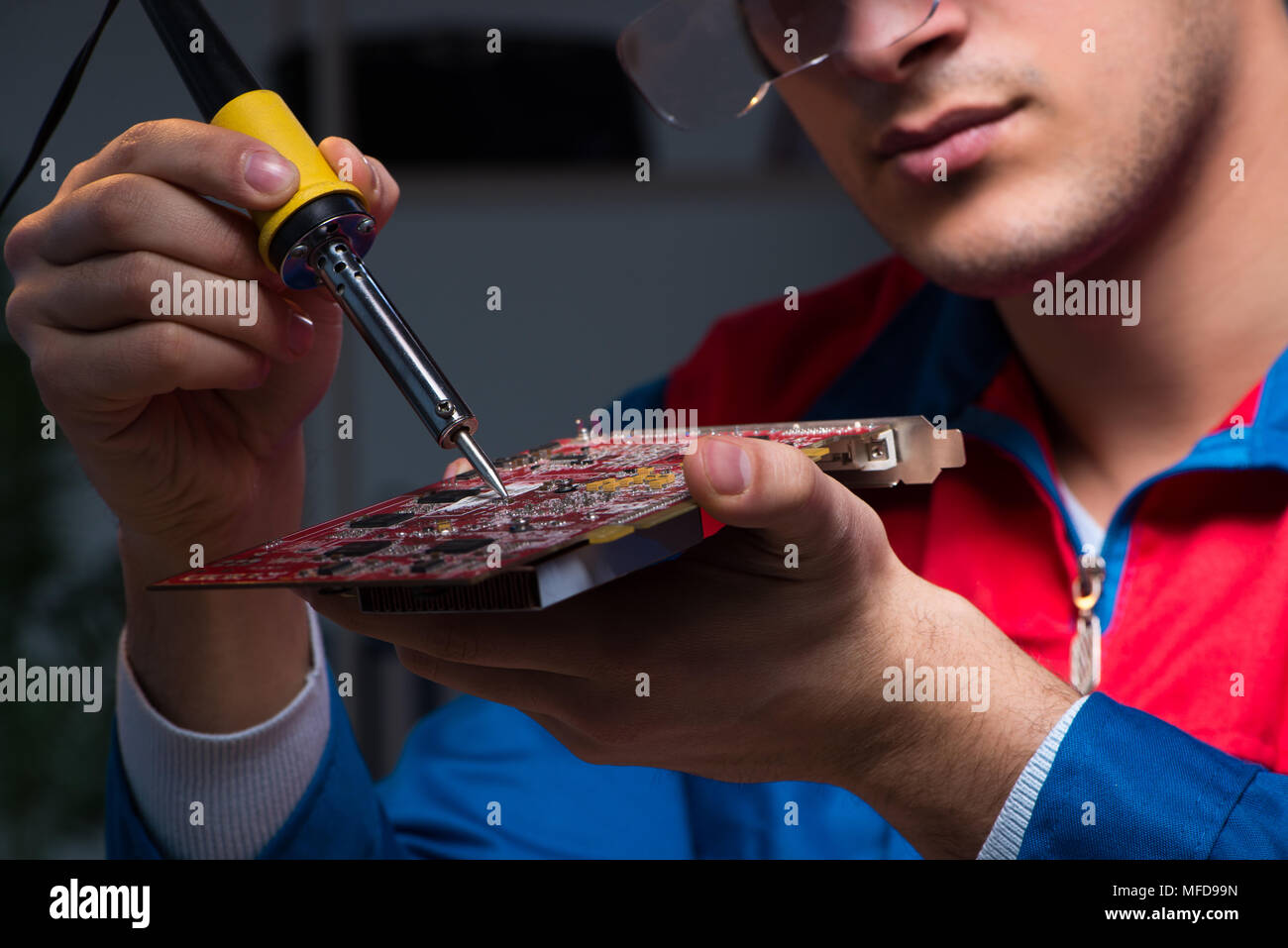 Computer specialist repairing PC late at night Stock Photo - Alamy