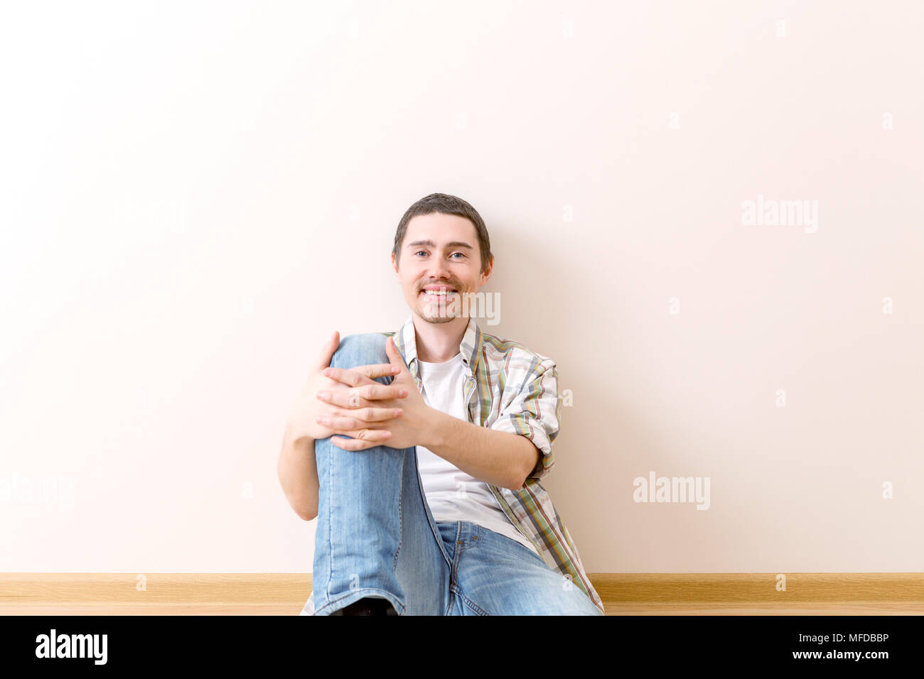 Image of laughing man sitting on floor Stock Photo - Alamy