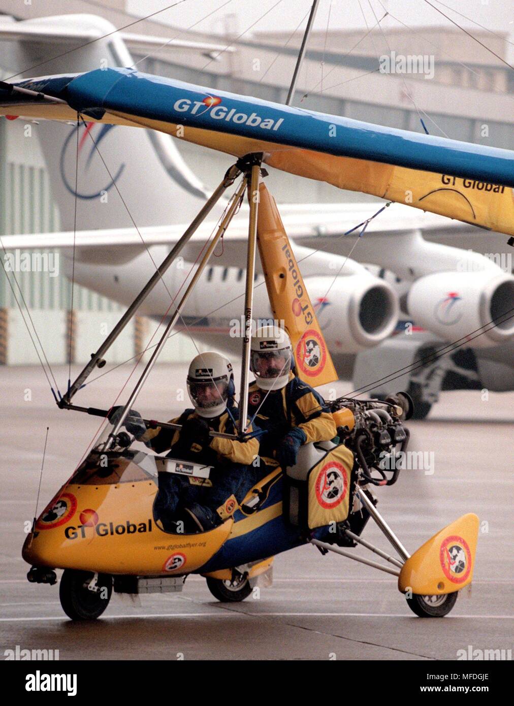 The ultralight aircraft of Brian Milton and Keith Reynolds from the United Kingdom taxi to the terminal of Berlin-Tempelhof Airport on February 13, 1998, in front of the jets of a traffic machine. In honor of the flight pioneers George Cayley (England) and Otto Lilienthal, the pilots who had started in Brompton Hall were the first ultralight planes to cross the North Sea. On March 15, 1998, the adventurers want to orbit the earth in 80 days, covering 38,881 kilometers with their aircraft. | usage worldwide Stock Photo