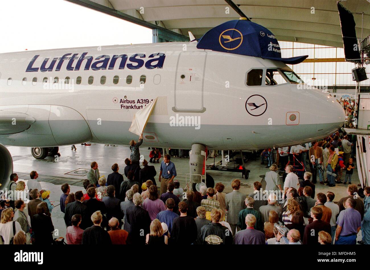 On the shoulders of an adult, a boy pulls down the disguise of the name tag on the day of the first Airbus A319 'Frankfurt/Oder' baptism on July 25, 1996 at the airport in Frankfurt am Main. The leash on the name tag was torn. As a 'little brother', the A319 completes the aircraft family of A320 and A321 and is used at Lufthansa on domestic German and European routes. Lufthansa will receive a total of 20 Airbus A319s until November 1998 and will replace the Boeing 737-200 sub-fleet with after and after. | usage worldwide Stock Photo