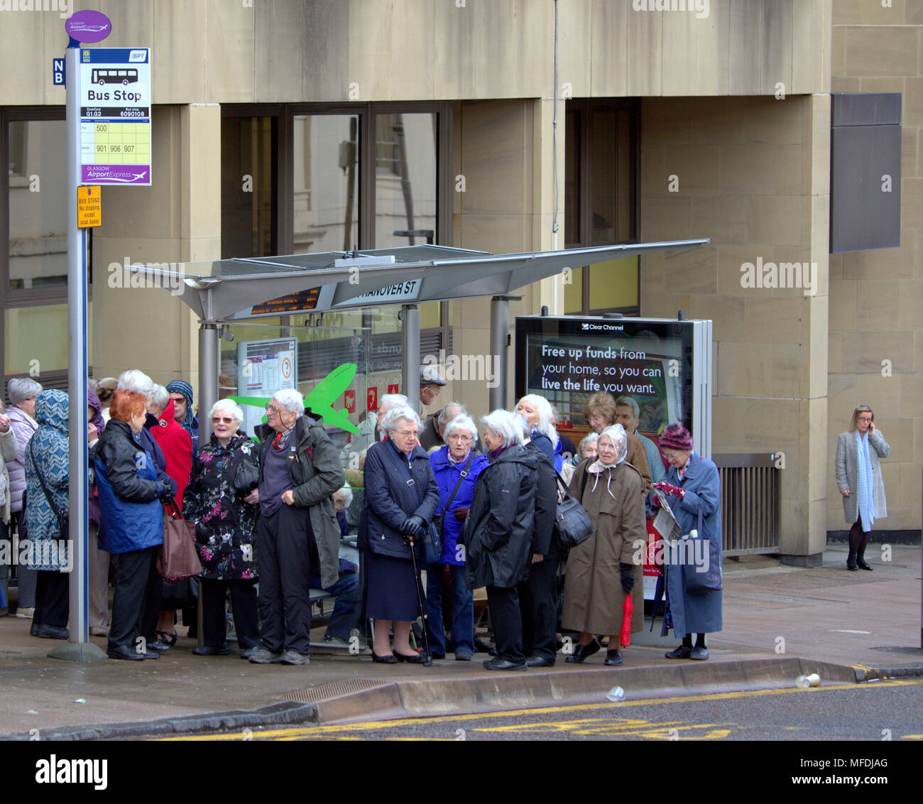 Glasgow, Scotland, UK 25th April. UK Weather: North Hanover street bus stop crowd line of pensioners in front of apt sell your home  advertisement sign Sunshine and showers as the locals and tourists enjoy the beginning of summer. Gerard Ferry/Alamy news Stock Photo