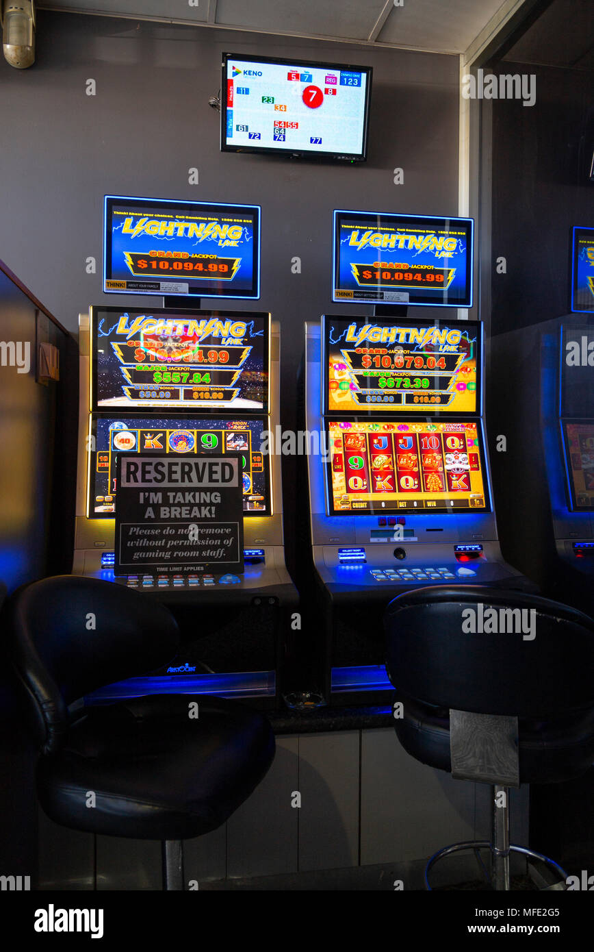 two poker slot machines at glen innes rsl club, one with reserve sign and Kino display on wall above Stock Photo