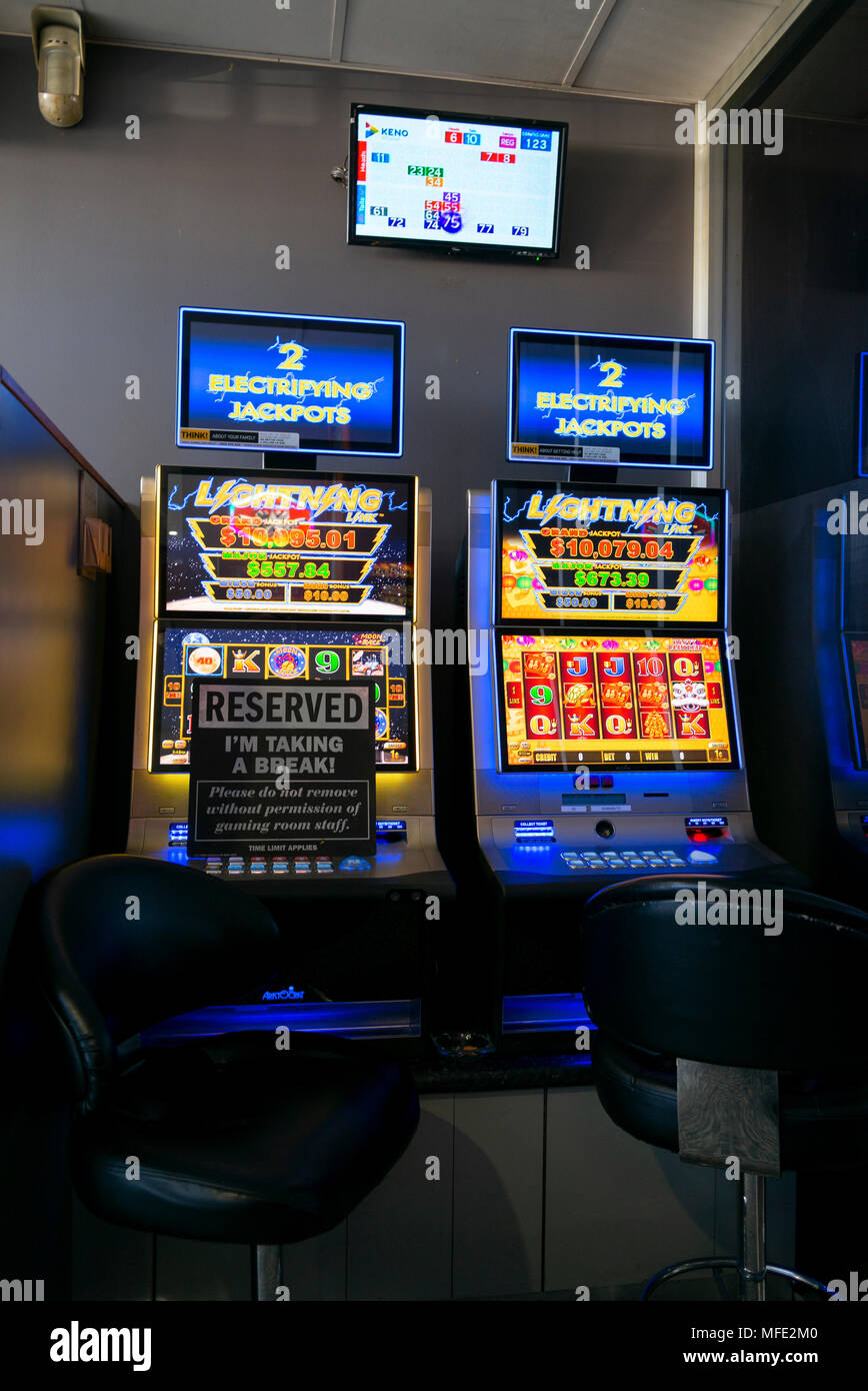 two poker slot machines at glen innes rsl club, one with reserve sign and  Kino display on wall above Stock Photo - Alamy