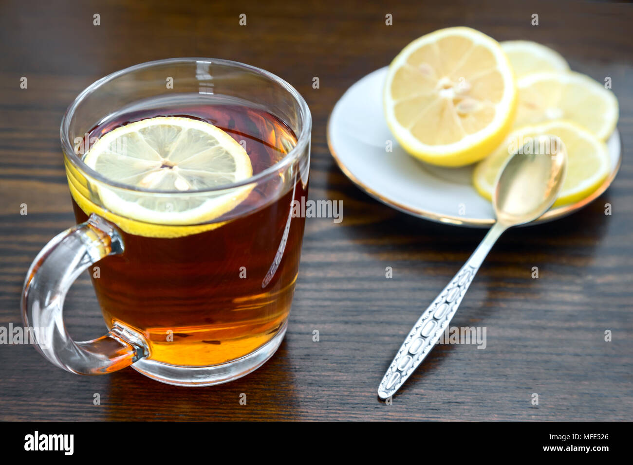 On the surface of the table in a glass Cup hot strong tea and lemon ...