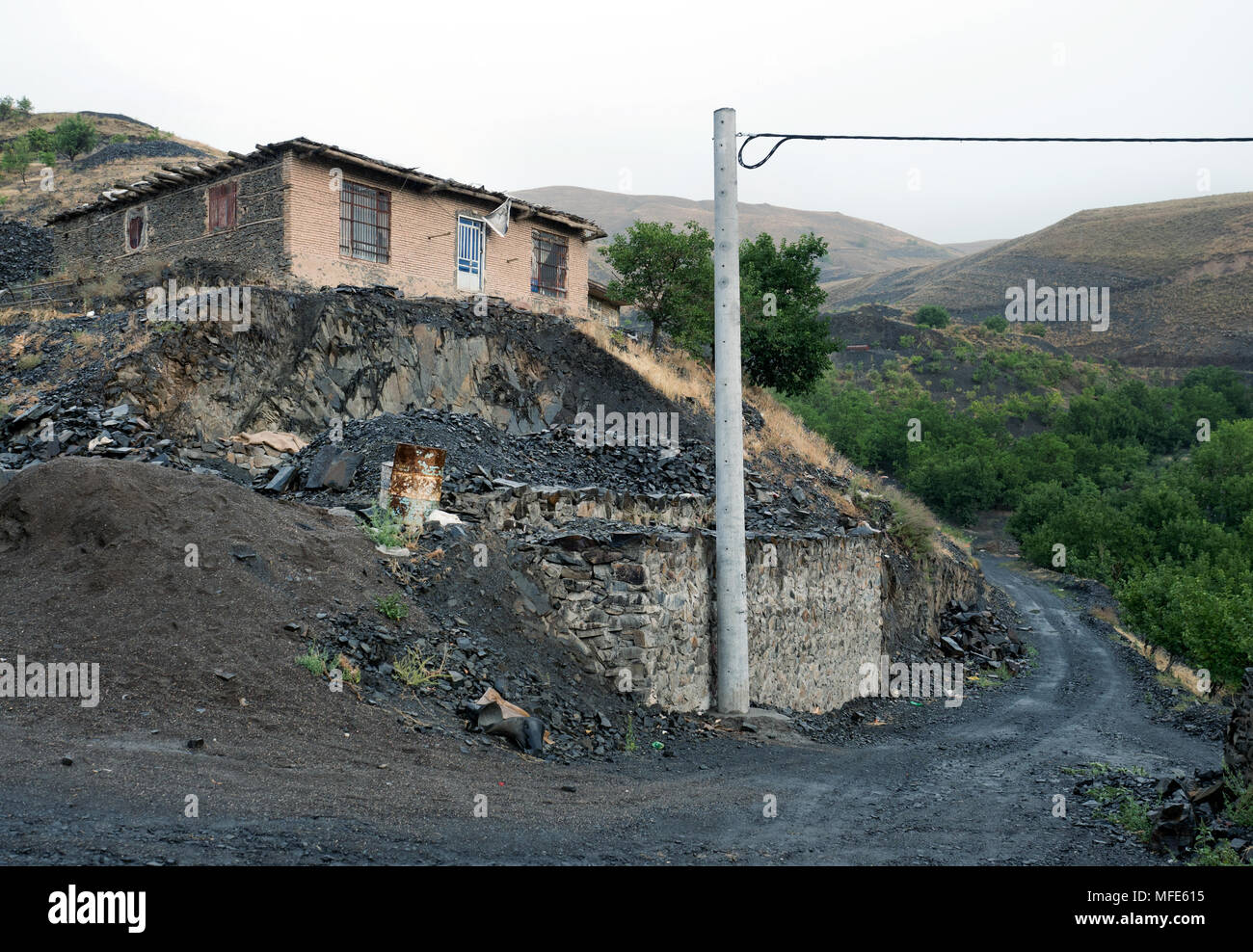 Black gravel road runing through the mountains around Mashhad, north-eastern Iran Stock Photo
