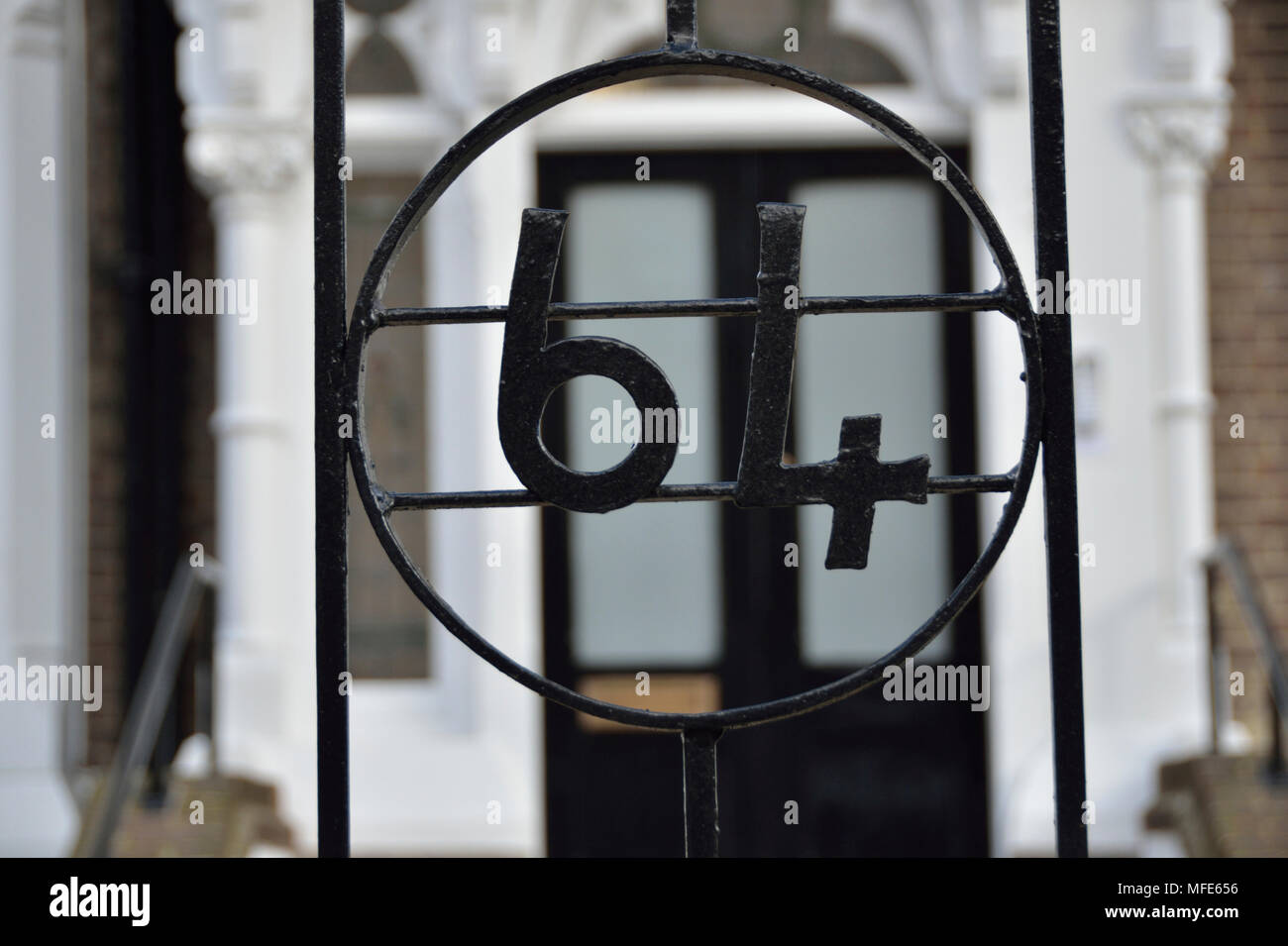 The number 64 sixty four on a house garden gate. Stock Photo
