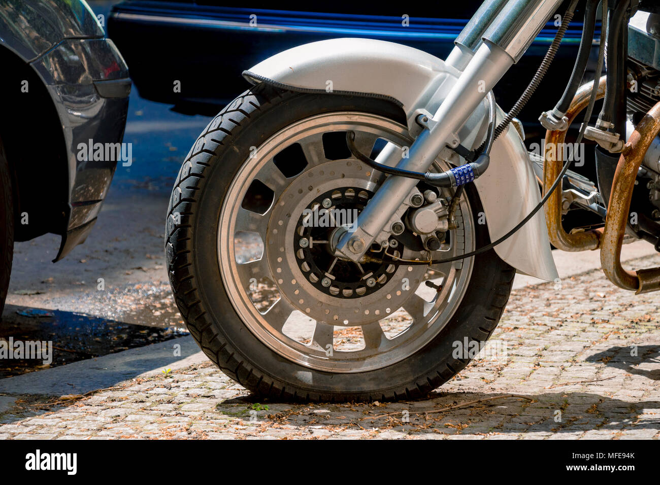 Security number padlock blocking motorcycle wheel on the street Stock ...