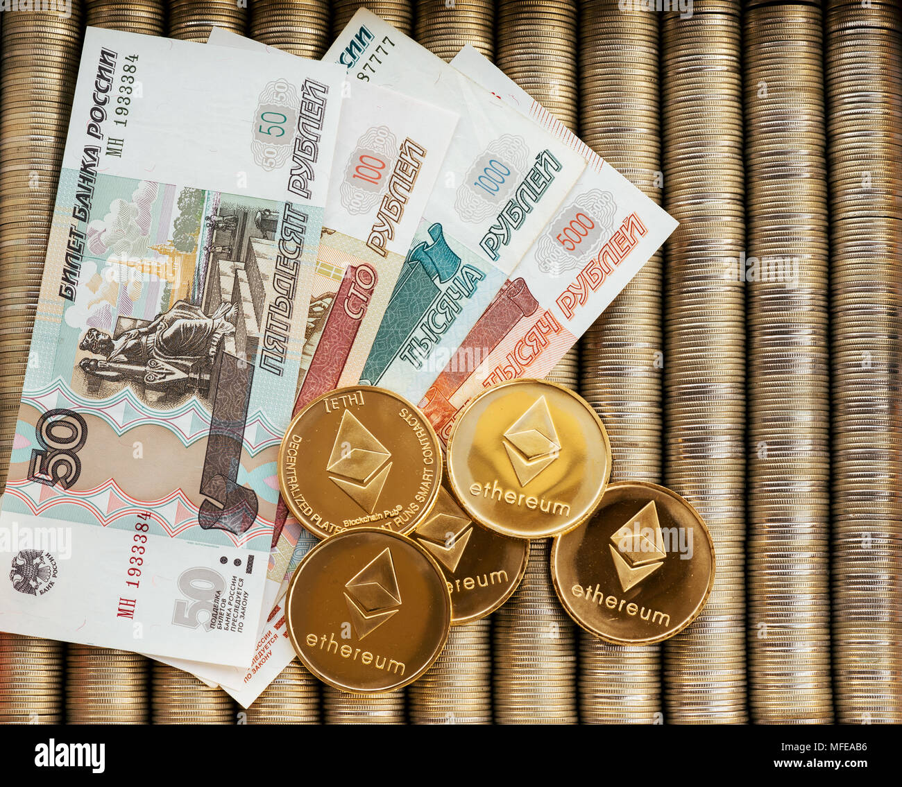 Gold crypto coins Ethereum ETH, paper denominations of Russian rubles.  Metal coins are laid out in a smooth background to each other, close-up  view fr Stock Photo - Alamy