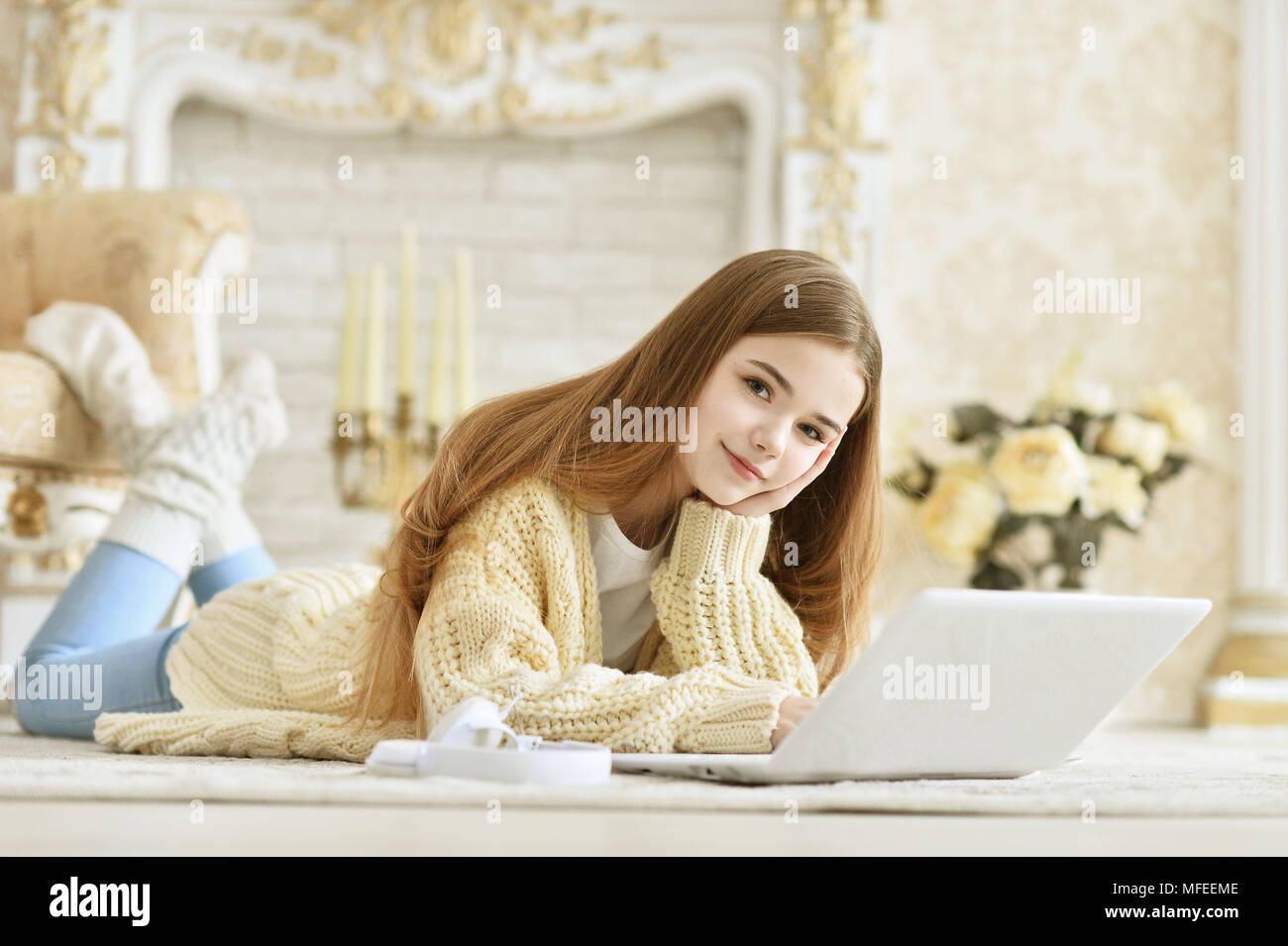 Beautiful teen girl lying on floor and using laptop Stock Photo - Alamy
