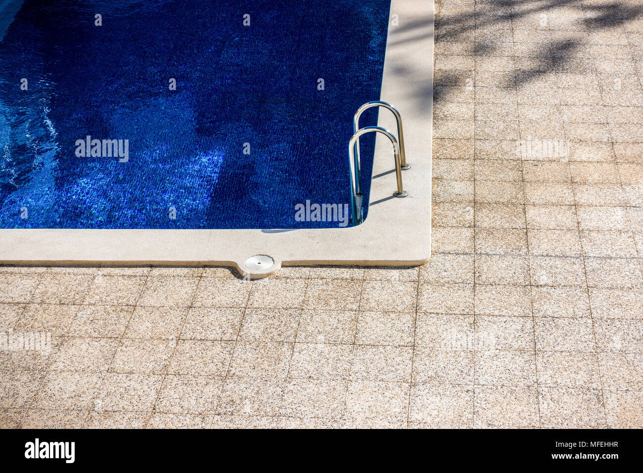 Swimming pool with metal chrome ladder Stock Photo - Alamy