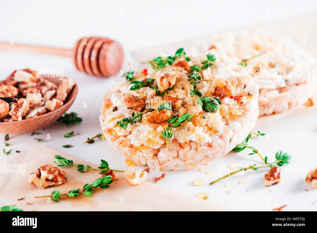 Healthy crisp bread toast with soft creamy cheese, honey, fresh thyme and nuts. Easy breakfast