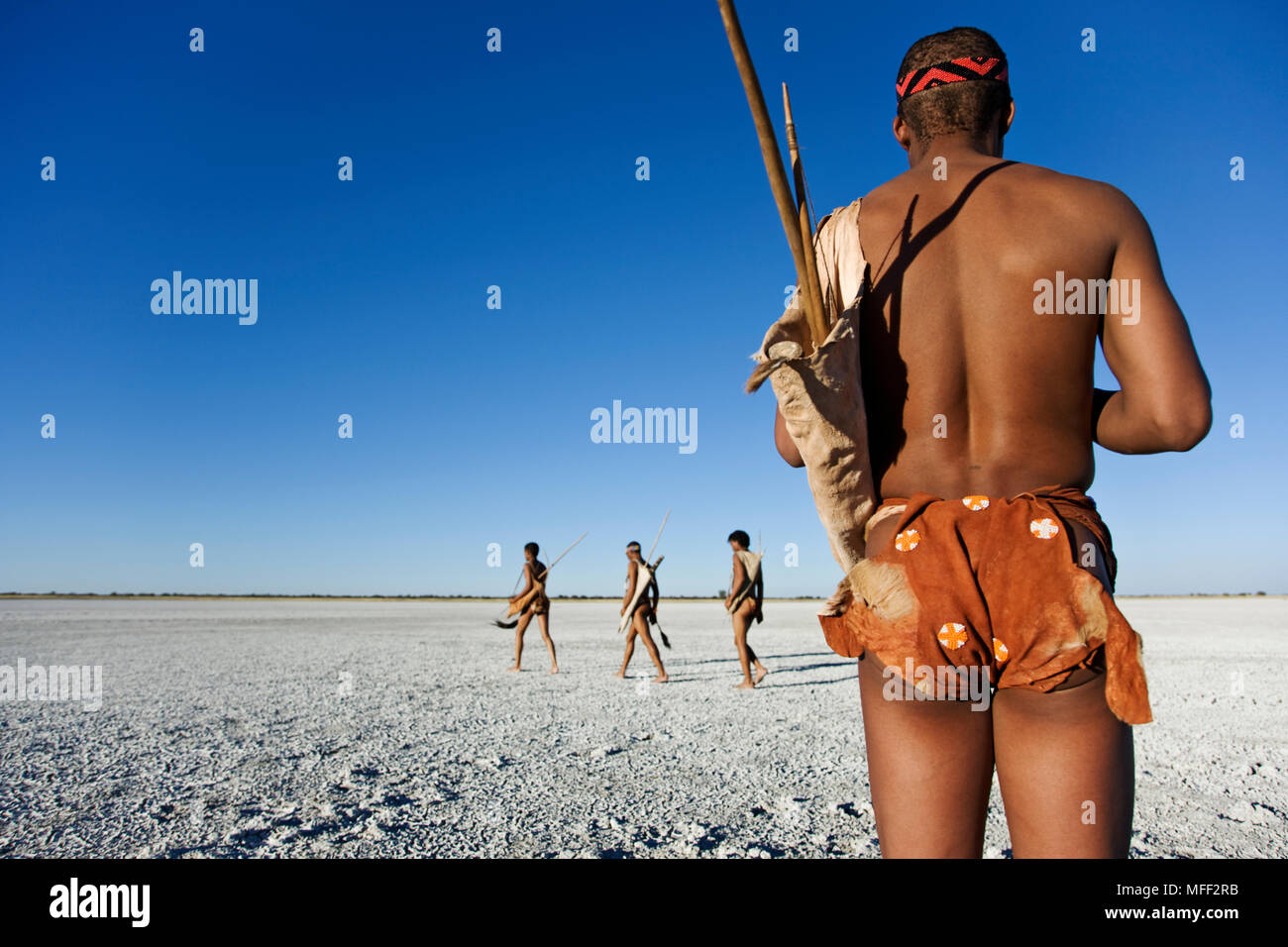 Bushmen wearing a shona on the Makgadikgadi Pans. The shona is made of steenbok or duiker skin and put on from the front with the smaller part between Stock Photo