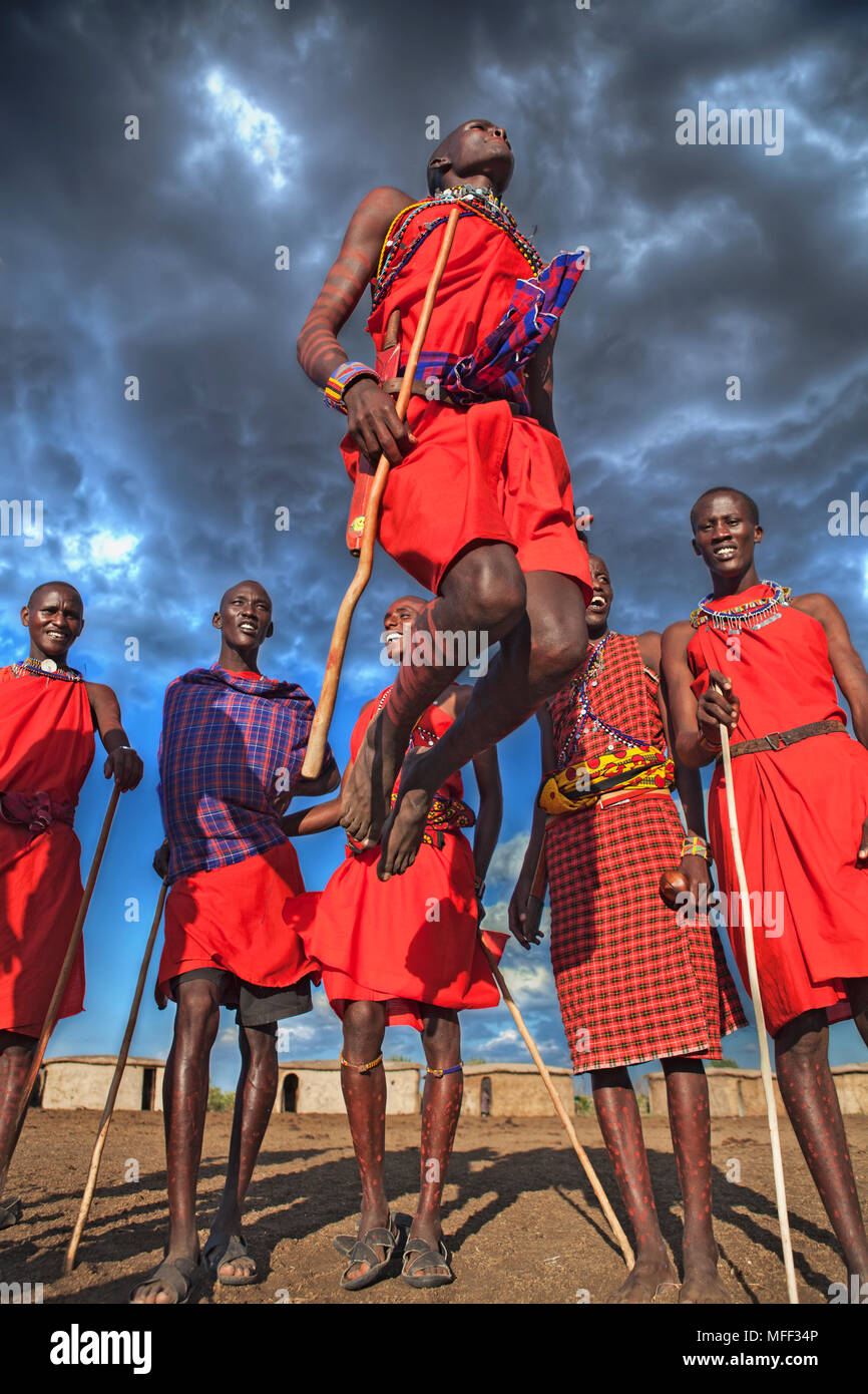 Masai warriors doing traditional dance. A circle is formed and one or two warriors will enter the circle to jump while maintaining  a straight posture Stock Photo