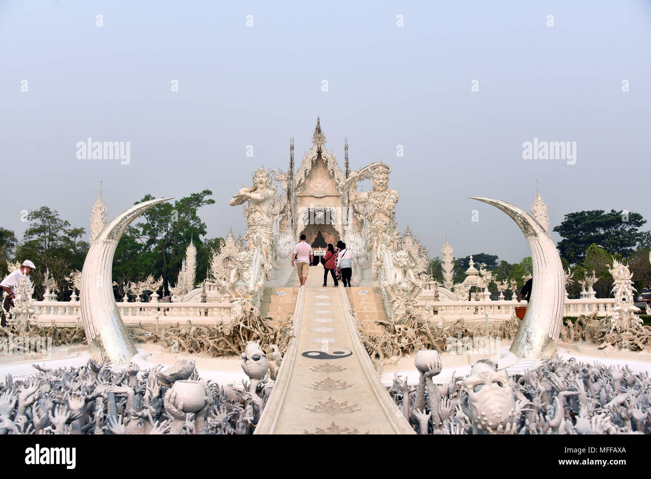 Hands of unrestrained desire and the bridge of rebirth leading to the main building (Ubosot) of Wat Rong Khun or the White Temple in Chiang Rai, North Stock Photo