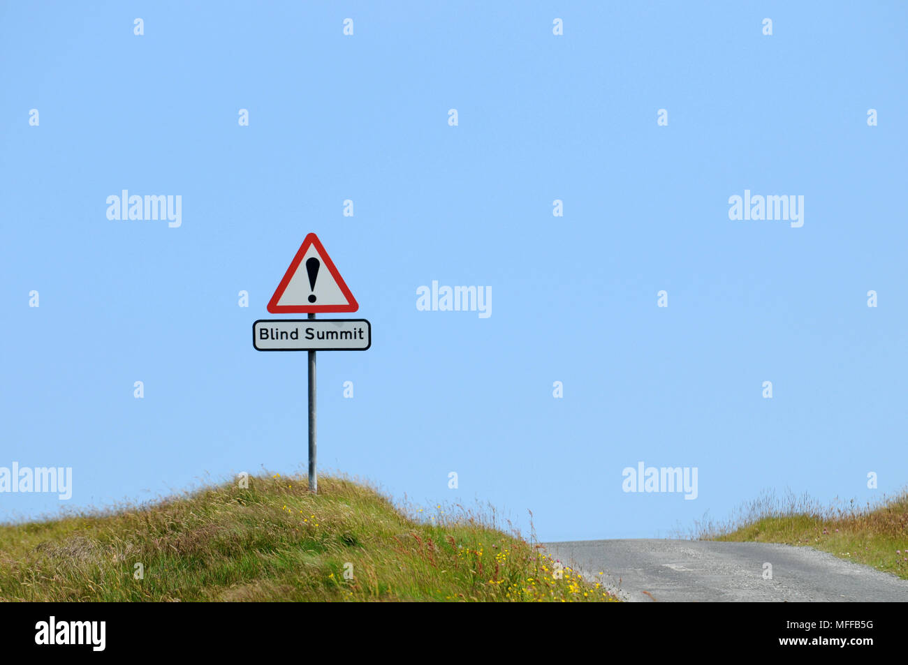Blind summit sign on a single track road Stock Photo