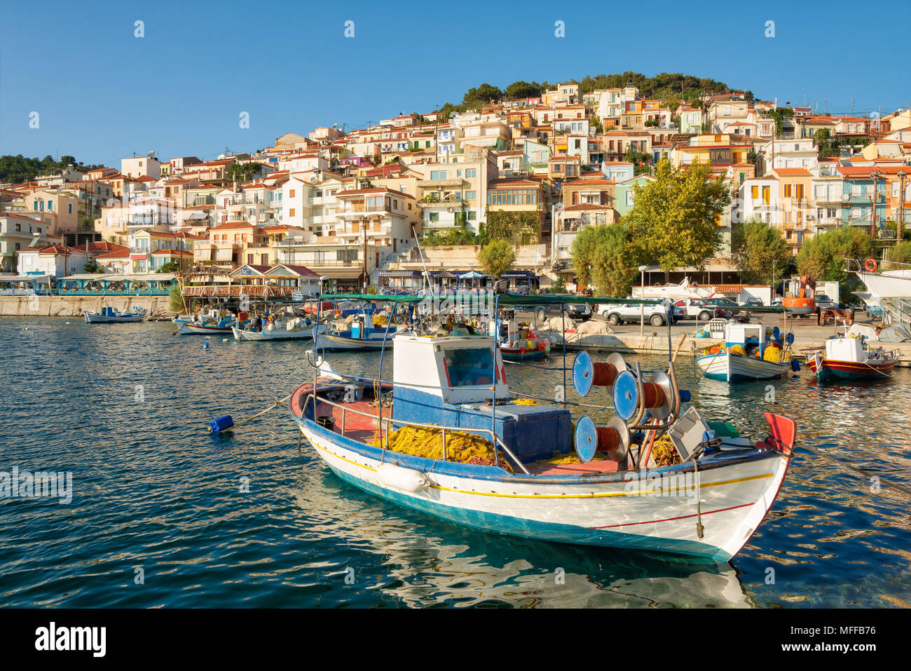 Panorama view of the picturesque port with traditional wooden fishing boats and the village Plomari in evening light, island Lesvos, Aegean Sea Greece Stock Photo
