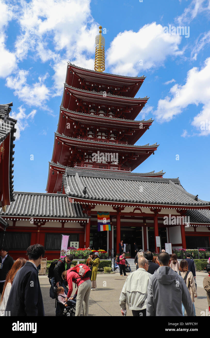 The impressive red five story pagoda, or goju-no-to, rises 157 ft above the Senso-ji Temple compound and tourists in Tokyo,Japan, against a blue sky, Stock Photo