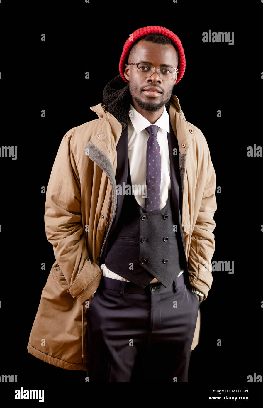 stylish Afro guy in white shirt. black vest, trousers, jacket and red cap  looking at the camera. student wearing coat Stock Photo - Alamy